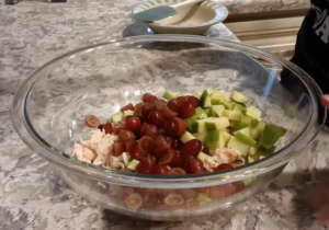 In a bowl, mix chicken, apple and grapes.