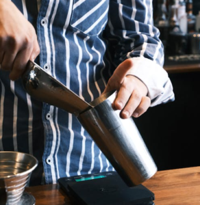 Fill a cocktail shaker with ice.